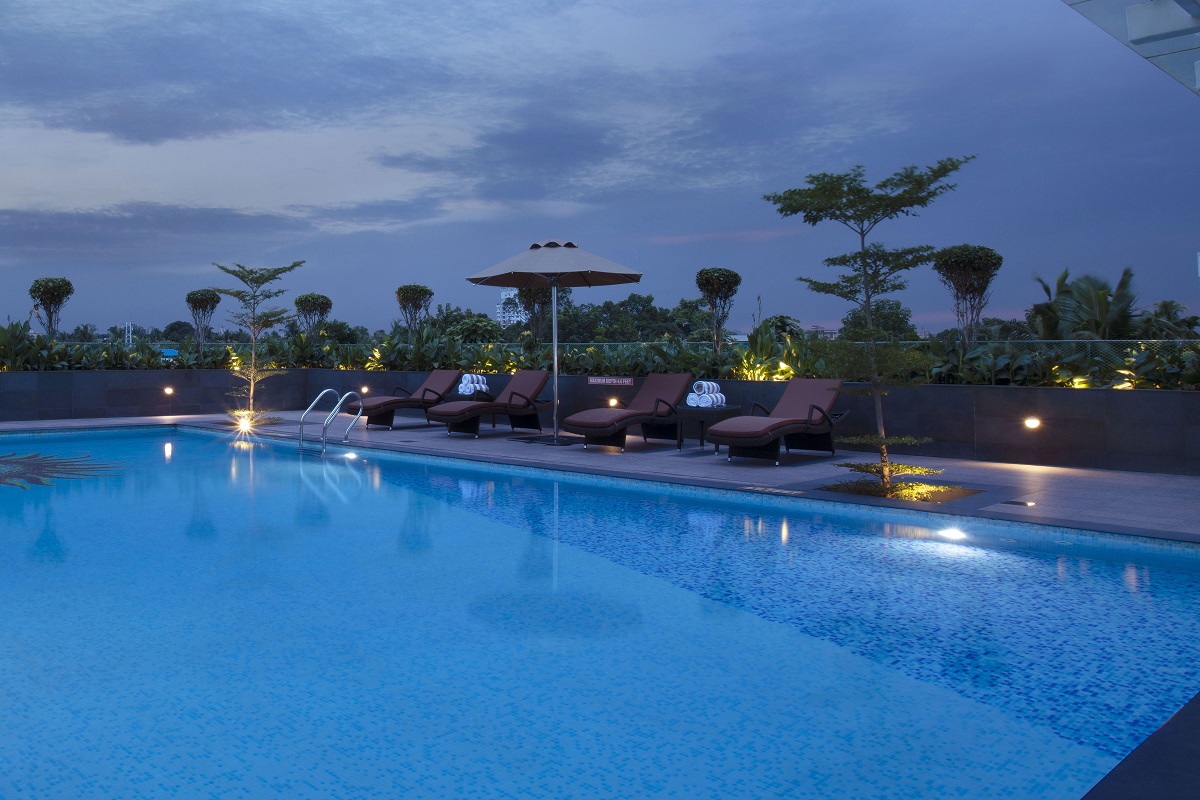 Rooftop swimming pool at Monsoon Empress luxury hotel in Kochi with open sky views