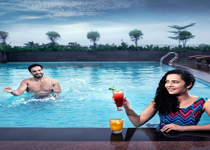 t: Swimming pool at Monsoon Empress, the best 5 star hotel in Kochi, with city skyline view.