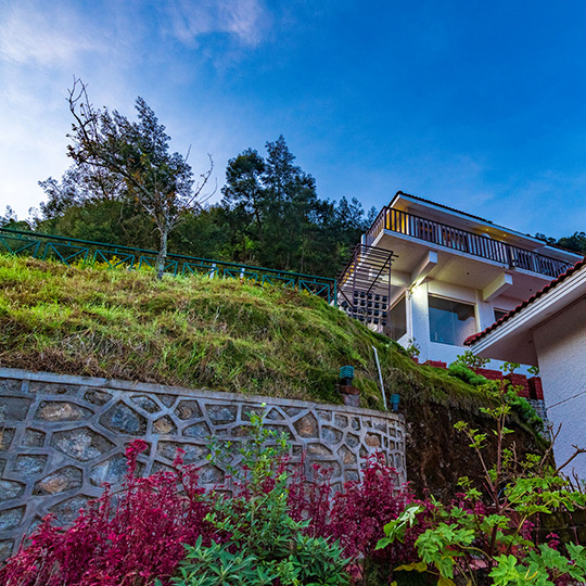 Warmth Hill Crest family resort in Kodaikanal featuring scenic valley view rooms, mist-covered hills, lush greenery, and a peaceful mountain retreat.